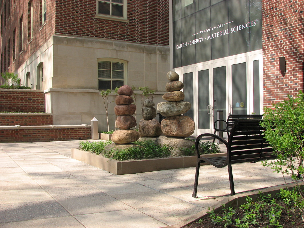 Exterior of a brick building showing a sculpture of stacked, rounded stones